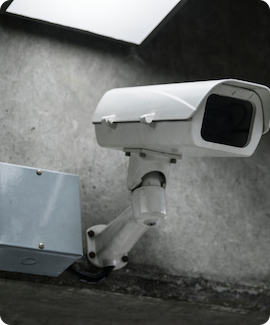 A security camera installed on a concrete wall, showcasing our CCTV services for enhanced safety and surveillance.